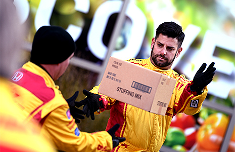 Andretti Autosport crew member Brad Redman tosses a box of stuffing.
